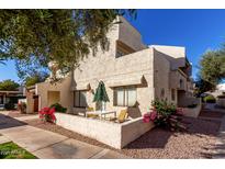 Charming condo featuring an outdoor patio seating area and vibrant floral landscaping at 11026 N 28Th Dr # 10, Phoenix, AZ 85029