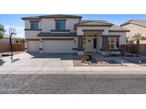 Beautiful two-story home featuring a three-car garage, covered porch, and desert landscaping at 2129 E Leo Pl, Chandler, AZ 85249