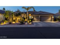 Inviting single-story home featuring lush desert landscaping and a spacious three-car garage at dusk at 3882 E Jaguar Ave, Gilbert, AZ 85298
