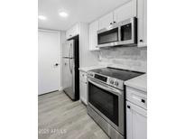 Modern kitchen features stainless steel appliances, white cabinets, and a stylish backsplash at 600 S Dobson Rd # 175, Mesa, AZ 85202