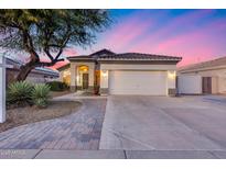 Charming single-story home featuring a two-car garage, desert landscaping, and a paved walkway leading to the entrance at 6214 W Irma Ln, Glendale, AZ 85308