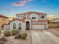 Charming two-story home with a red tile roof, stucco exterior, arched windows, desert landscaping and an attached two-car garage at 647 E Palomino Way, San Tan Valley, AZ 85143
