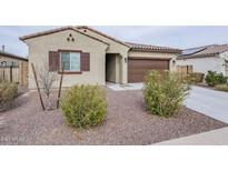 Charming single-story home with a two-car garage, desert landscaping, and a neutral color palette at 142 W Atlantic Dr, Casa Grande, AZ 85122