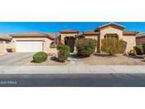 Beautiful tan single-story home with a well-manicured desert landscape and a two car garage at 7776 E Sands Dr, Scottsdale, AZ 85255