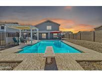 Inviting backyard pool with diving board, patio, and pergola, perfect for outdoor entertaining at sunset at 900 E Rosebud Dr, San Tan Valley, AZ 85143