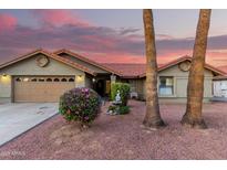 Charming home featuring desert landscaping, tile roof, and a two car garage at 9014 E Sharon Dr, Scottsdale, AZ 85260