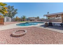 Spacious backyard with a pool, firepit, outdoor grill, and desert landscaping at 10417 S 44Th St, Phoenix, AZ 85044