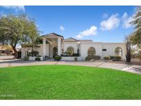 Stunning home with a beautiful lawn and manicured landscaping in front at 10541 E Windrose Dr, Scottsdale, AZ 85259