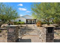 Charming home exterior features a well-manicured front yard, desert landscaping and inviting walkway to the front door at 11212 N Miller Rd, Scottsdale, AZ 85260