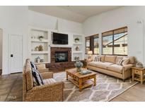 Bright living room boasts a cozy stone fireplace, built-in shelves, and large windows at 14994 W Charter Oak Rd, Surprise, AZ 85379