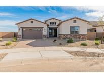 Charming single-story home featuring stone accents, neutral stucco, paver driveway, and a two-car garage at 17347 W Chama Dr, Surprise, AZ 85387