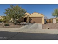 Charming single-story home with desert landscaping, a spacious driveway, and a two-car garage at 25742 N 103Rd Dr, Peoria, AZ 85383