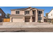Two-story home featuring a driveway, a two-car garage, and solar panels on the roof at 3124 W Redbird Rd, Phoenix, AZ 85083