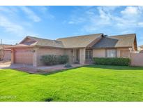Charming single-story brick home with lush green lawn, mature landscaping, and a two-car garage at 3523 W Kelton Ln, Phoenix, AZ 85053