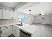 Bright kitchen featuring white cabinets, stainless steel appliances, and a view to the living area at 4737 E Belleview St, Phoenix, AZ 85008