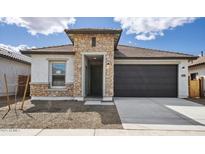 Charming single-story home featuring stone accents, a two-car garage, and a low-maintenance desert landscape at 7649 W Minton St, Laveen, AZ 85339