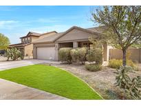 Attractive single-story home with desert landscaping, green grass, and a two-car garage at 10721 W Jefferson St, Avondale, AZ 85323