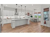 Open-concept kitchen with a central island, stainless steel appliances, and dining area at 11241 N Blakely St, Surprise, AZ 85388