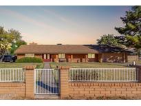 Charming brick home with a well-maintained front yard and inviting red double-door entrance at 14251 N 182Nd Ave, Surprise, AZ 85388