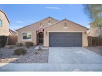 Charming single-story home featuring neutral stucco, a two-car garage, desert landscaping, and an American flag at 2009 E Lindrick Dr, Gilbert, AZ 85298