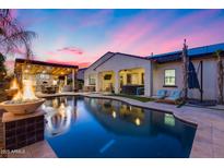 Inviting backyard with a sparkling pool, covered patio, outdoor kitchen, and comfortable lounge seating at 20125 E Via Del Rancho --, Queen Creek, AZ 85142