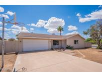 Charming one-story home with a basketball hoop and a well-manicured lawn under a bright sky at 2359 W Del Oro Cir, Mesa, AZ 85202