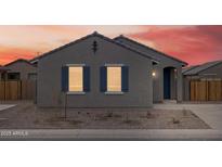 Charming single-story home featuring blue shutters and low-maintenance landscaping against a vibrant sunset backdrop at 2673 E San Miguel Dr, Casa Grande, AZ 85194