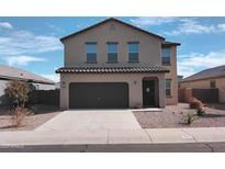A modern two-story home with a dark garage door and desert landscaping at 374 S Verdad Ln, Casa Grande, AZ 85194