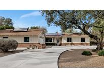 Charming ranch-style home with a manicured lawn, solar panels, and a spacious driveway at 576 W Moon Valley Dr, Phoenix, AZ 85023