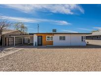 Charming single-story home with modern curb appeal, a carport, and low maintenance gravel landscaping at 829 W Mitchell Dr, Phoenix, AZ 85013