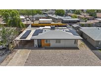 Charming home featuring solar panels, gravel landscaping, and a convenient covered carport for easy parking at 829 W Mitchell Dr, Phoenix, AZ 85013