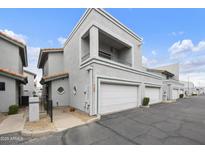 View of the exterior elevation of a two-story townhouse with an attached garage and a balcony with metal railing at 8614 N 67Th Dr, Peoria, AZ 85345