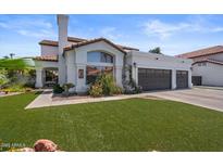 Charming single-story home featuring a tile roof, a three-car garage, and a well-manicured lawn at 1233 E Azure Sea Ln, Gilbert, AZ 85234