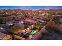 Expansive aerial view of home with pool, patio, and mountain views at dusk, in the community at 18059 W Ocotillo Ave, Goodyear, AZ 85338