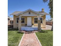 Charming bungalow with a brick walkway, freshly cut green grass, and cozy front porch at 2209 N 8Th St, Phoenix, AZ 85006