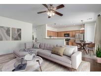 Comfortable living room with hardwood floors that connects to an open kitchen area at 25792 W Burgess Ln, Buckeye, AZ 85326