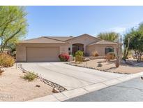 Charming beige home featuring a two-car garage, desert landscaping, and a welcoming entrance at 27913 N Walnut Creek Rd, Rio Verde, AZ 85263