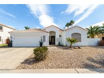 Charming single-story home showcasing desert landscaping, a tiled roof, and a clean white facade at 2909 N 111Th Dr, Avondale, AZ 85392