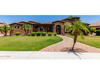 Beautiful desert landscaping graces the front yard with lush green lawn providing curb appeal at 3464 E Dartmouth St, Mesa, AZ 85213
