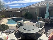 Inviting backyard pool area featuring a cozy fire pit and comfortable patio furniture at 39743 N High Noon Way, Anthem, AZ 85086