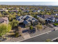 Stunning aerial view of custom home with stone accents, tiled roof, mature landscaping, and mountain views at 5421 E Juniper Canyon Dr, Cave Creek, AZ 85331