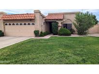 Charming single-story home with lush green lawn and a beautiful tile roof at 9196 E Evans Dr, Scottsdale, AZ 85260