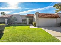 Charming single-story home with a well-manicured front lawn and mature landscaping at 9463 E Jenan Dr, Scottsdale, AZ 85260