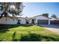 Charming single-story home featuring a well-manicured lawn and a two car garage at 15440 N 54Th St, Scottsdale, AZ 85254