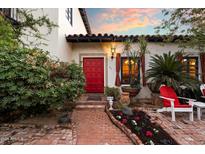 Charming home featuring a red front door with colorful tile accents and a brick walkway lined with flowers at 1614 Palmcroft Sw Dr, Phoenix, AZ 85007