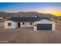 Beautiful single-story home features a two-car garage, desert landscaping and mountain views at 16560 N Slate Ln, Maricopa, AZ 85139