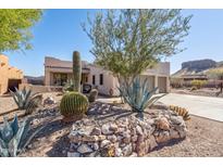 Southwestern-style home with desert landscaping featuring cacti, agave, and a rock retaining wall at 4309 S Priceless View Dr, Gold Canyon, AZ 85118