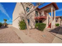 Charming two-story condo with well-maintained landscape and stairway to the balcony at 455 S Delaware Dr # 106, Apache Junction, AZ 85120