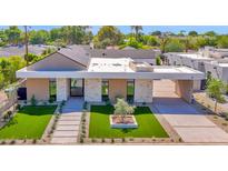 Stunning modern home featuring stone accents, a covered driveway, and professionally landscaped front yard at 4704 N 40Th Pl, Phoenix, AZ 85018