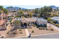 Expansive desert landscaping defines this single-story home with a large, flat roof and mountain views at 5345 E Mercer Ln, Scottsdale, AZ 85254